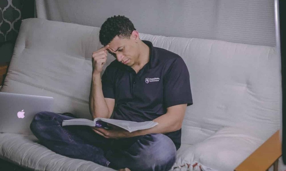 man sitting on sofa reading book 1467564