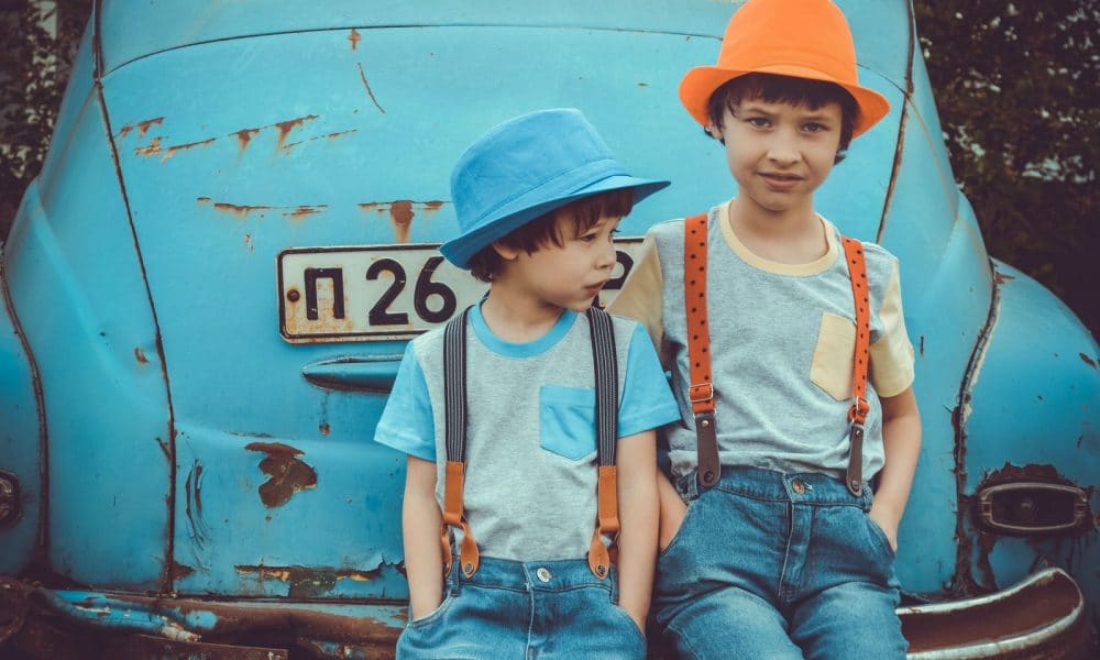 Two Boys Sitting on Blue Volkswagen Beetle Coupe's Rear Bumper