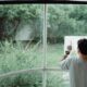 Father Carrying His Son and Pointing at Something Through the Window 