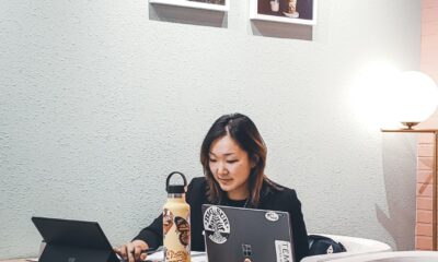 woman sitting behind table with black laptop computer