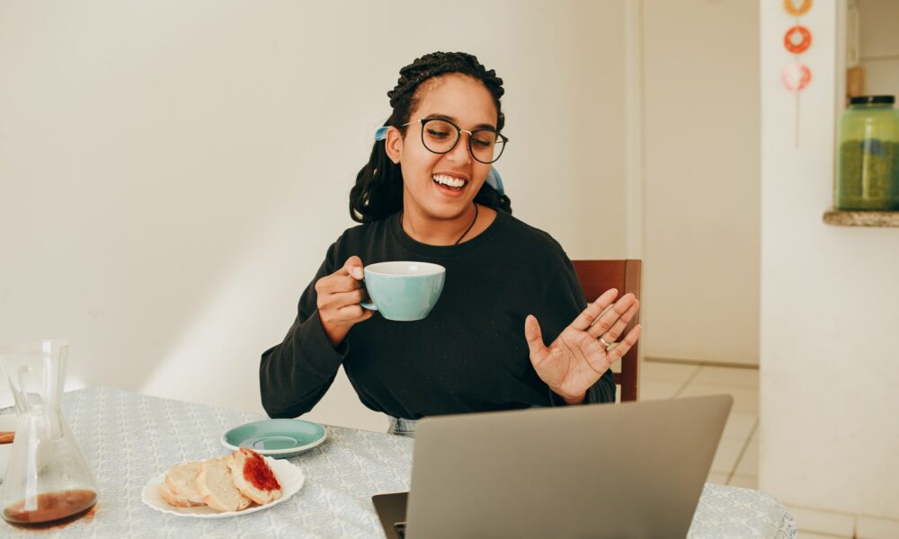 woman in black long sleeve shirt holding white ceramic mug