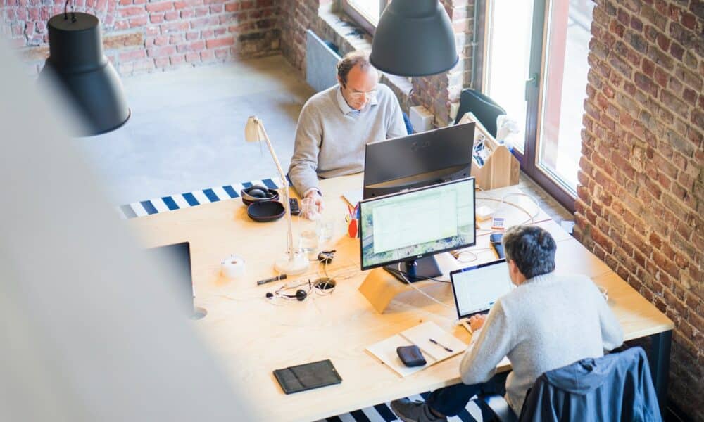 Two Men Sitting Facing on Flat Screen Monitors
