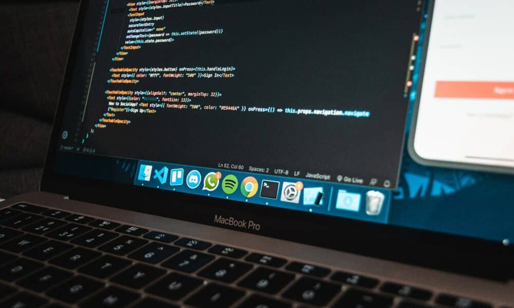 Workplace with modern laptop with program code on screen