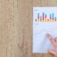 Person Pointing Paper Line Graph