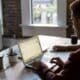 man operating laptop on top of table