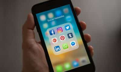 Person Holding Iphone Showing Social Networks Folder