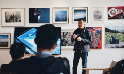 Man Beside Flat Screen Television With Photos Background
