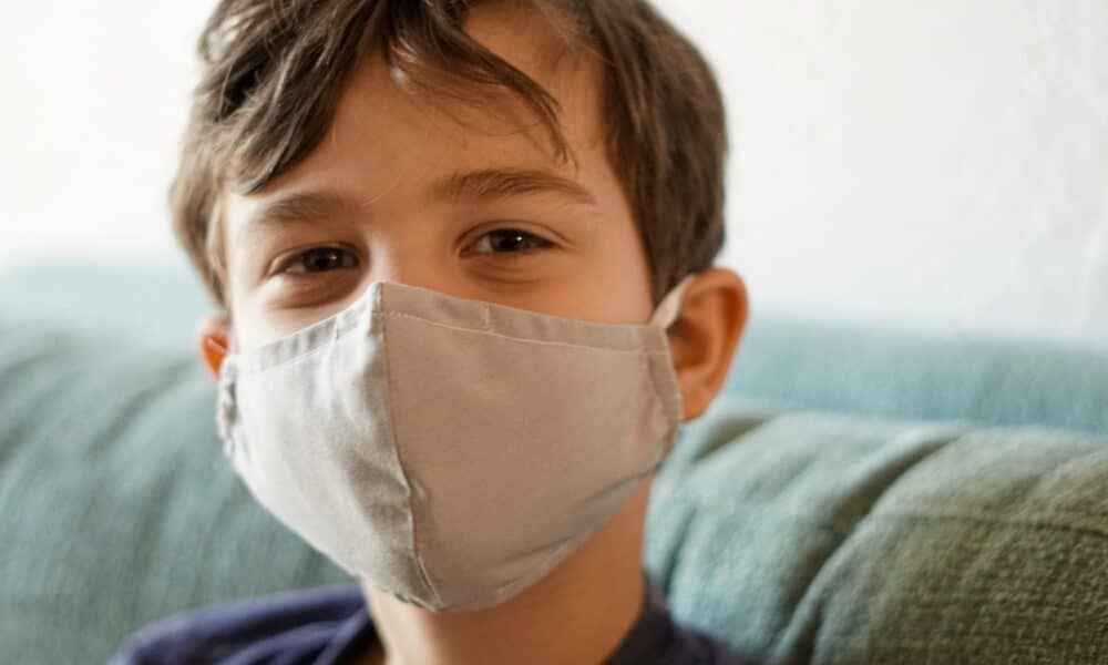boy in blue crew neck shirt with white face mask