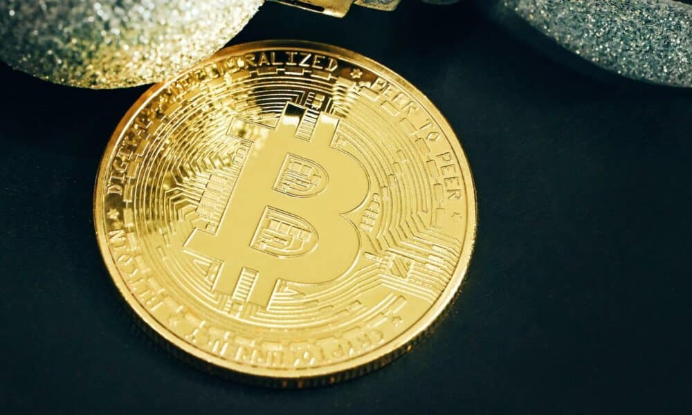 a gold bit coin sitting on top of a black table