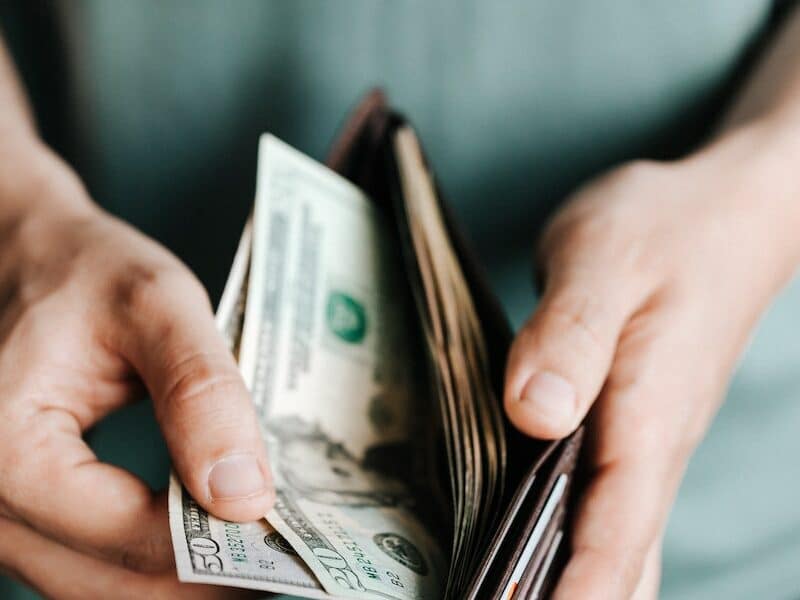 Crop man getting dollars from wallet