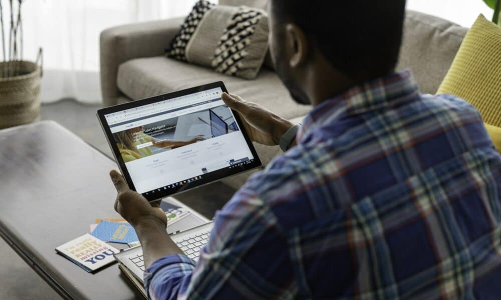A Person in Blue Plaid Long Sleeves Holding a Tablet