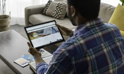 A Person in Blue Plaid Long Sleeves Holding a Tablet