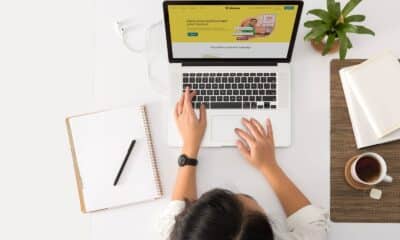 a person sitting at a desk with a laptop and a coffee cup