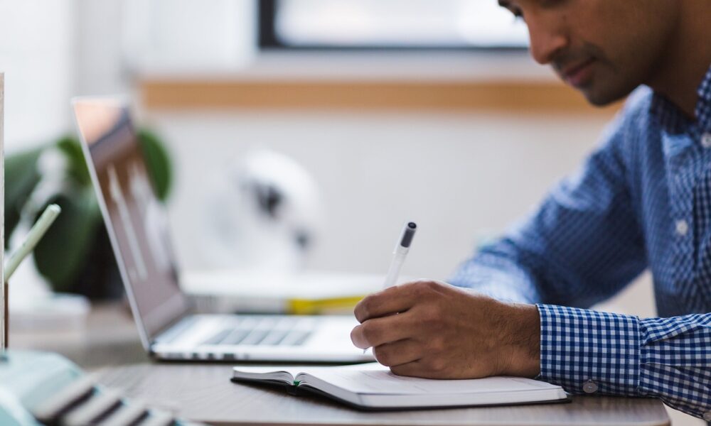 man, writing, laptop