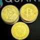 three gold bitcoins sitting on top of a black table