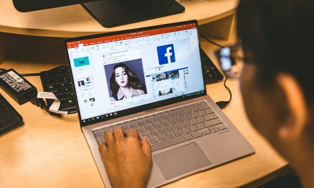 person using laptop browsing facebook application