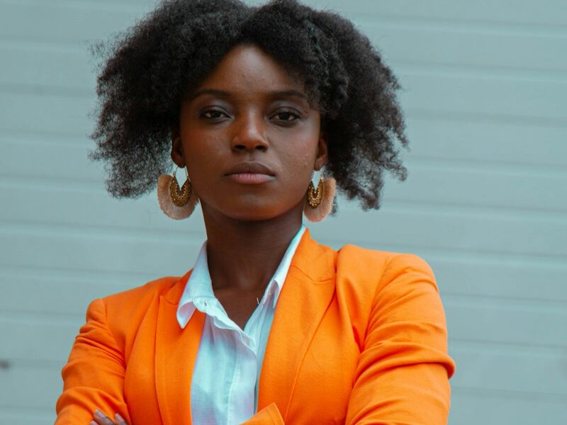 woman in orange blazer standing