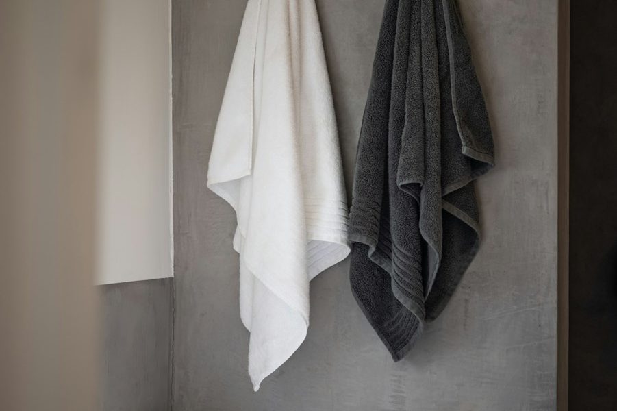 white bath towel on white ceramic bathtub