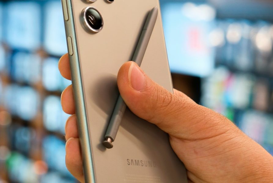a person holding a silver cell phone in their hand