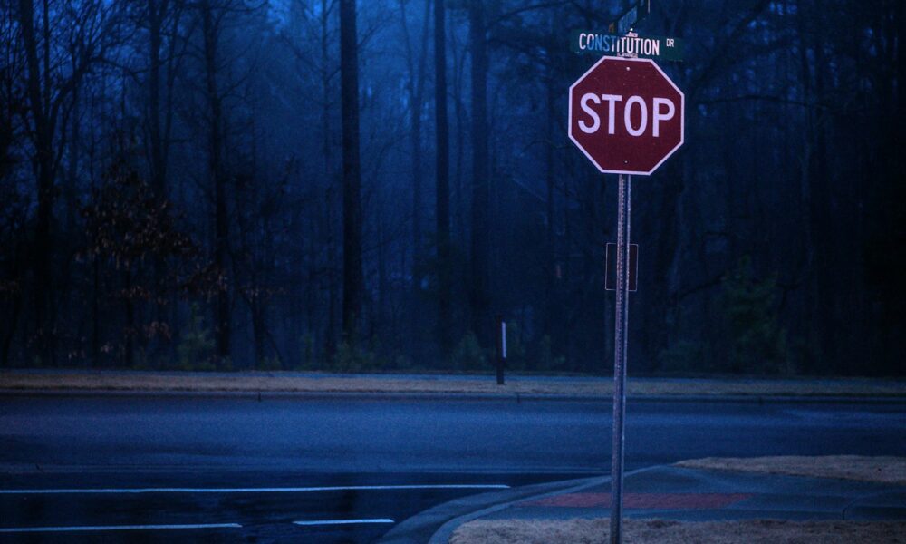 stop road sign on sidewalk near forest