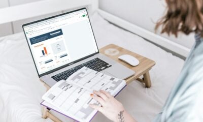 a person sitting on a bed with a laptop