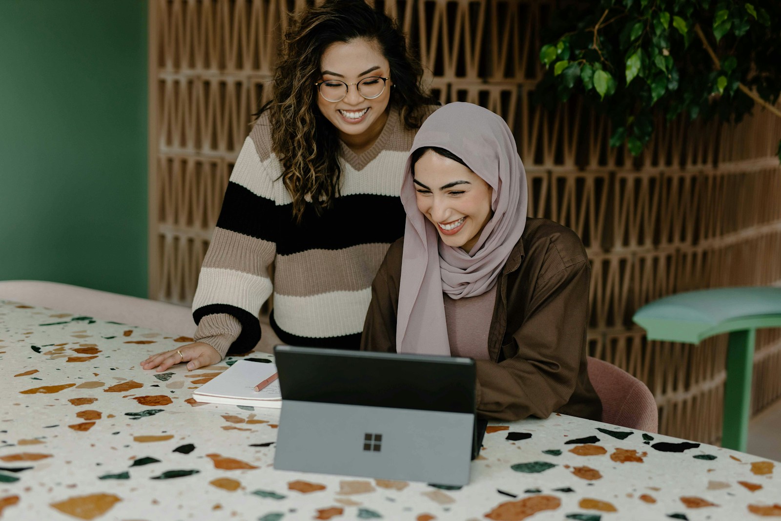 Elevate Your Brand with Custom Business Products: A Strategic Investment 16 Two women sitting at a table with a laptop