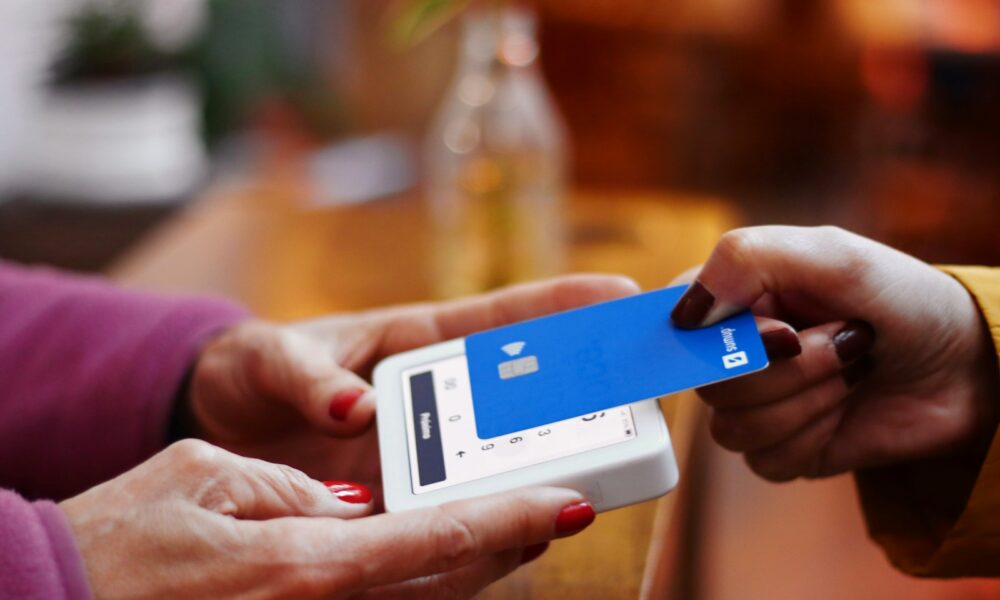 a person holding a credit card and a cell phone