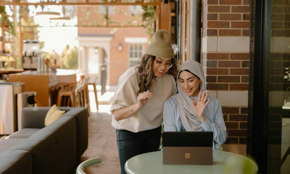 a woman sitting at a table using a laptop