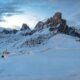 A mountain covered in snow under a cloudy sky