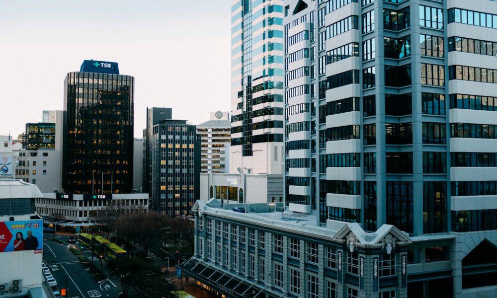 A bustling urban skyline with modern skyscrapers and city streets during the day.