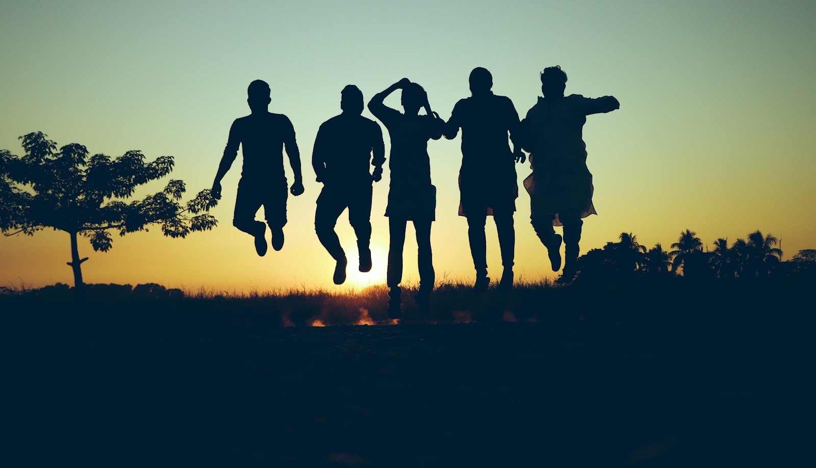 Saja Boys: The Rising Icons of Gen-Z Culture and Style 16 silhouette of people standing on grass field during sunset