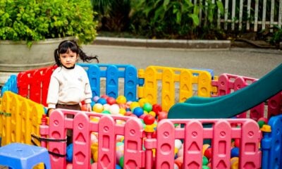 A little girl plays in a colorful ball pit.