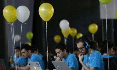 a group of people sitting at a table with laptops