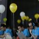 a group of people sitting at a table with laptops