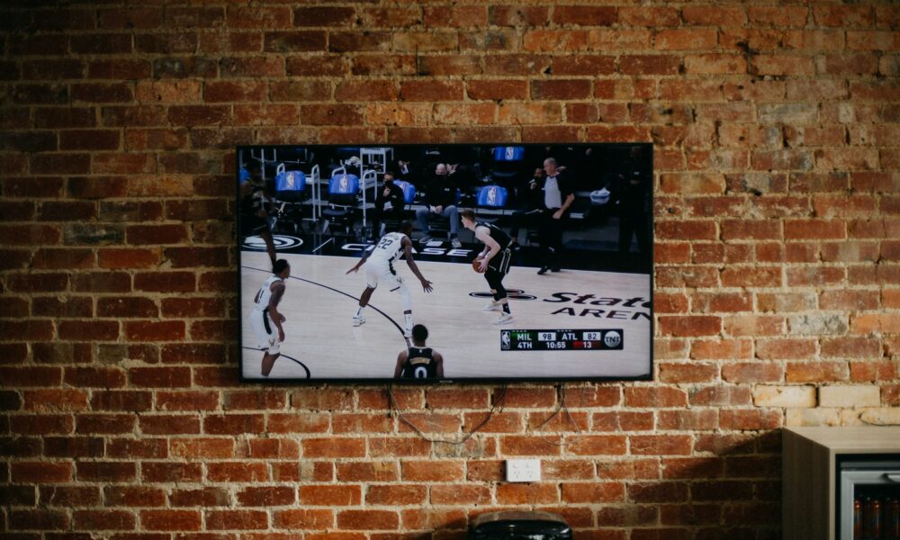 black flat screen tv mounted on brown brick wall