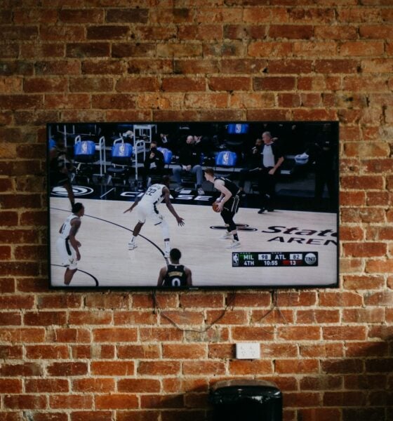 black flat screen tv mounted on brown brick wall