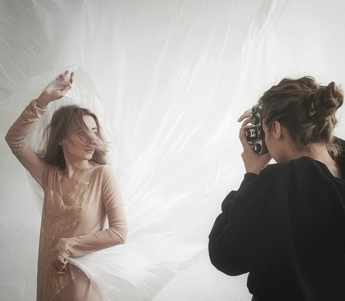 woman taking photo of woman in beige V-neck long-sleeved dress