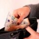 a woman is holding a wallet full of money