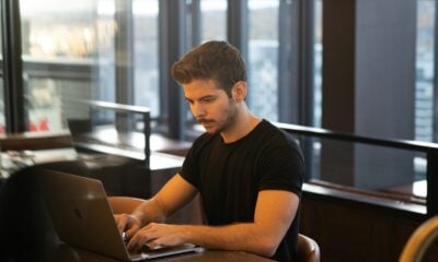 man in black crew neck t-shirt using macbook