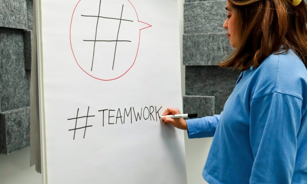 a woman writing on a white board with a marker