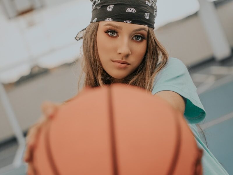 a young woman holding a basketball on a basketball court