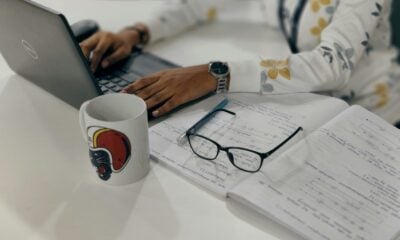 a woman sitting at a table with a laptop computer