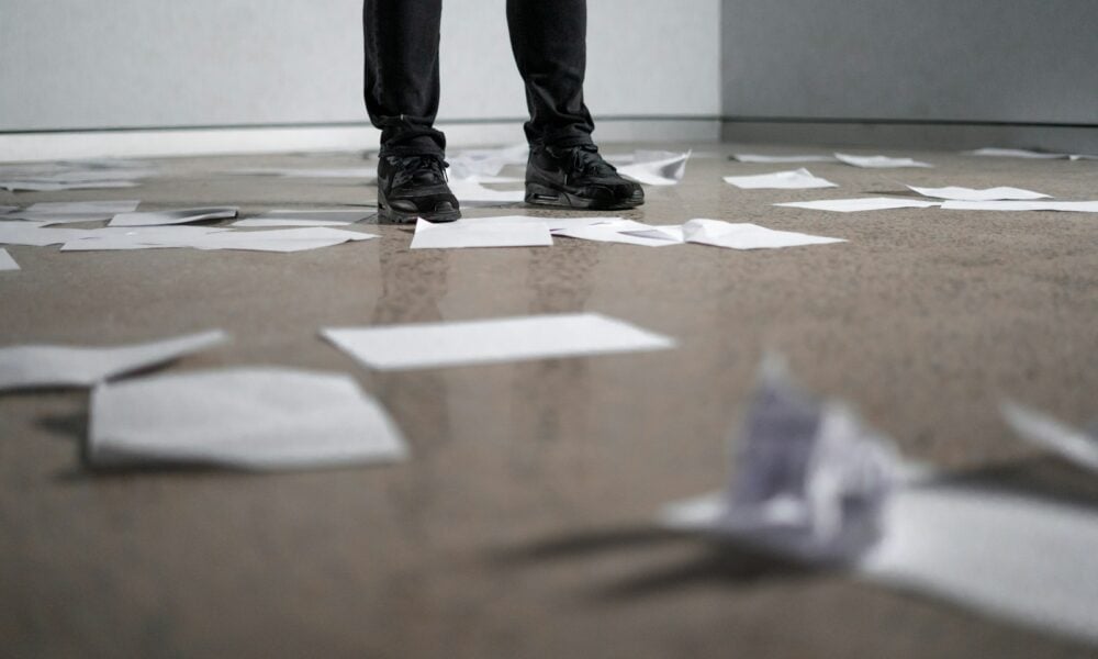 person standing near papers on ground