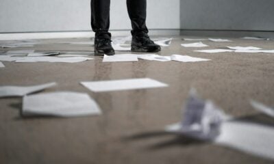 person standing near papers on ground