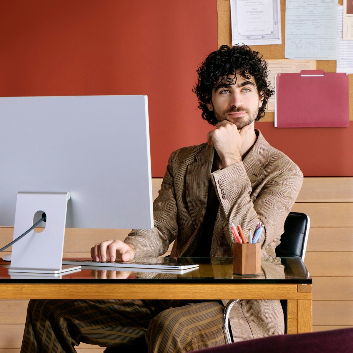 Feestech Com: Unlocking Tech Insights 16 Man sitting at desk with computer, resting chin