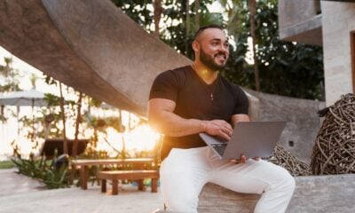 man in brown crew neck t-shirt and white pants sitting on brown wooden bench during