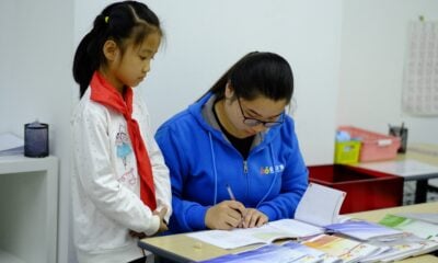 a woman and a girl are doing something on a desk