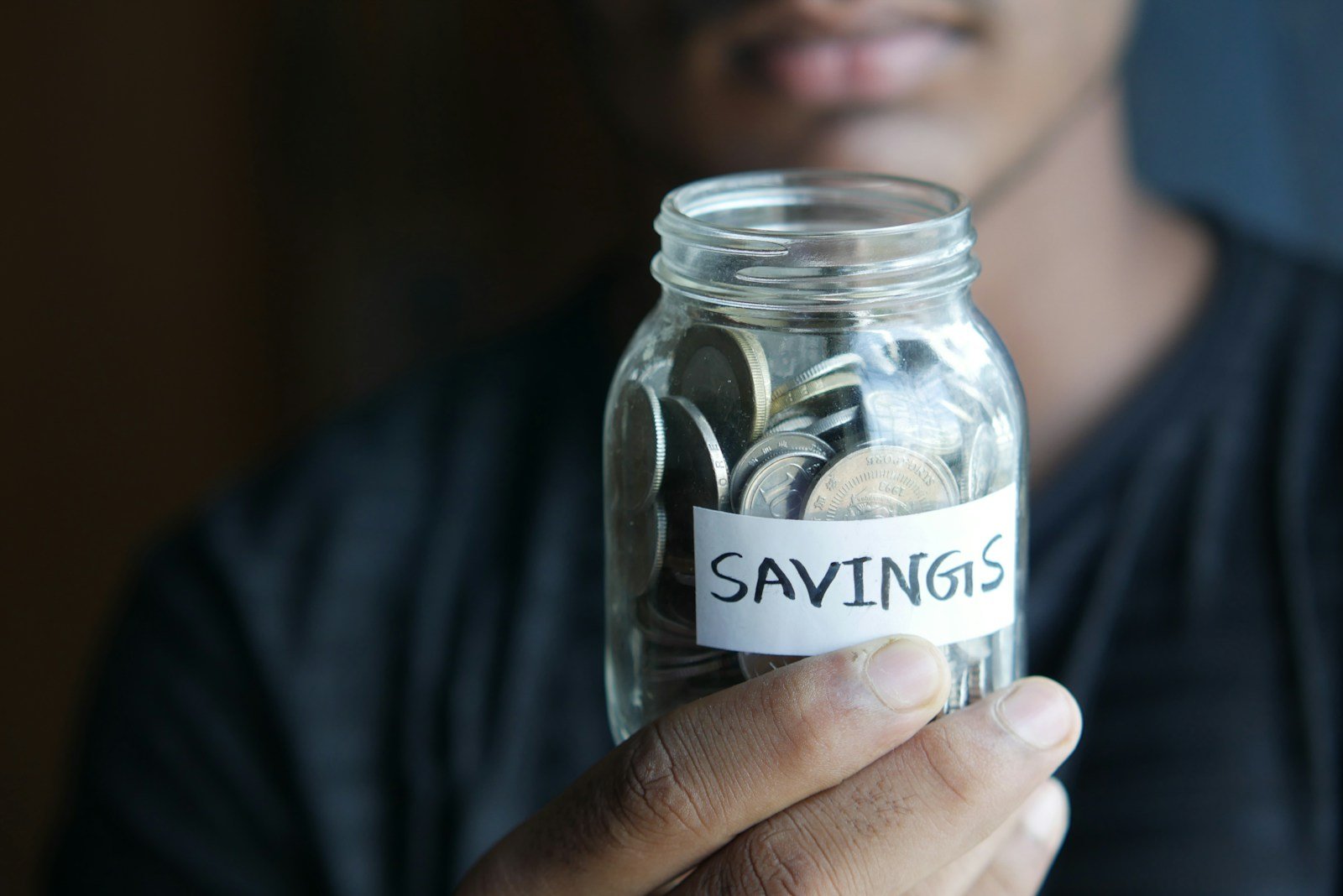 How to Pick a Savings Plan When Your Child’s College Is Still 15 Years Away? 16 a man holding a jar with a savings label on it