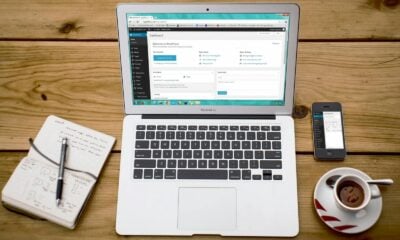 A cozy home office scene with a laptop, notebook, smartphone, and coffee, perfect for productivity.