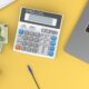 a calculator sitting on top of a desk next to a laptop